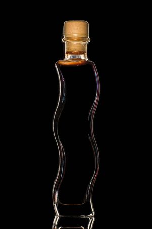 A bottle of balsamic vinegar on a dark isolated background.の写真素材