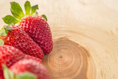 Berry strawberry whole and cut into slices close-up on a wooden background . .Summer mood. seasonal berriesの写真素材