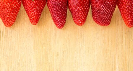 Berry strawberry whole and cut into slices close-up on a wooden background . .Summer mood. seasonal...