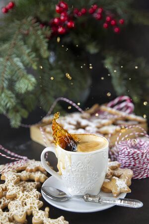 Winter, holidays.Close-up of splashing hot coffee and cookies . Christmas, decorations for the holidays. The mood of the occasion.の写真素材