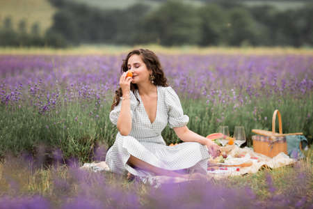 The summer season.Lavender fields. A girl on a picnic in the flowering fields of lavender.Vacation in the country,countryside.の写真素材