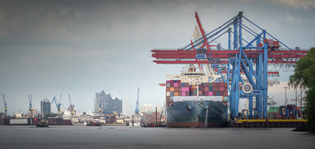 A container ship at the terminal in reasonably good weather in Hamburgの写真素材