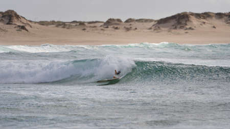 Surfers not on but in the waveの写真素材