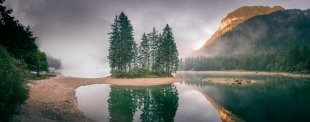 Sunrise over the lake with fog in the mountainsの写真素材