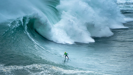 A surfer in the waves of NazarÃ© in Portugal