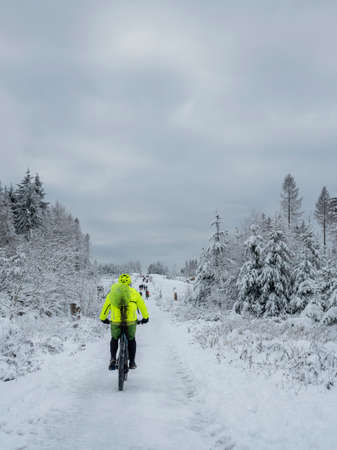 A nice picture of a mountainbiker on a snowy forest path, an intresting photoの写真素材