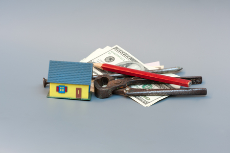 Little symbolic house, money and contruction toolsの写真素材