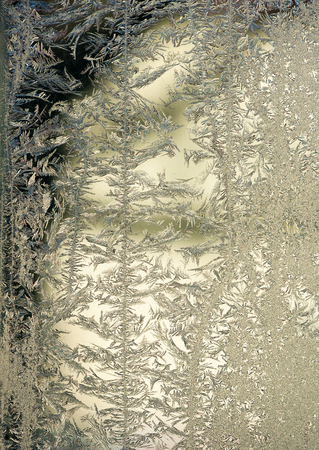 Black frost patterns on a windowの写真素材
