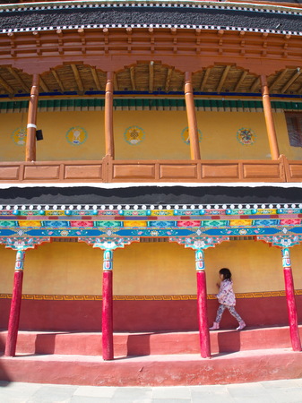 a girl walking in Tibetan Buddhist Temple. Leh, Kashmir, India - April 16th, 2017