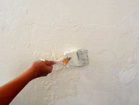 Old grunge concrete wall with removed white acrylic paint.Painting Preparation at homeの写真素材