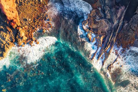 Rocky coastline and highway with golden sand and blue water, post processed in HDR