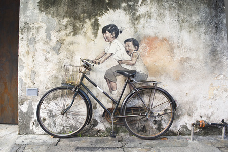 Little Children on a Bicycle or Sibling Cyclist Street Art Mural in Armenian Street, George Town, Penang by Lithuanian artist Ernest Zacharevic in George Town, Penang, Malaysia.のeditorial素材