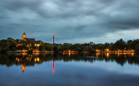 May 2016 - dramatic sky in Chemnitz on well-known pond with a church and industrial chimney in the background - Saxony, Germany.の写真素材