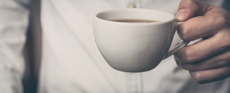 Take a break - man is holding cup of fresh coffeeの写真素材