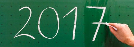 Man is changing year 2016 to 2017 on chalkboardの写真素材