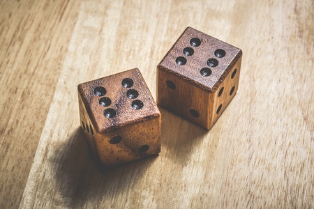 Two wooden dice with the number 6 on a tableの写真素材