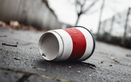 Used Coffee mug at sidewalk as symbol for pollution.の写真素材