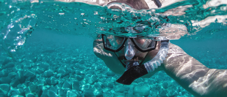 Young man takes underwater selfie.