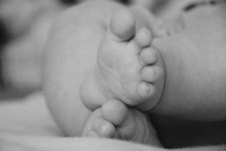 Baby, infant feet black and white photo, beautiful background for card,  banner, wallpaper designの写真素材