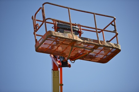 Commercial Boom Lift Cage Closeup on Blue Clear Sky.