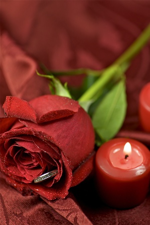 Red Rose Engagement Ring. Red Candles and Soft Burgundy Background Fabricの写真素材