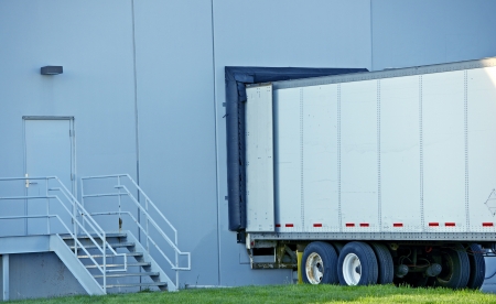 Semi Truck Delivery. Truck Trailer in Warehouse Dock. 
