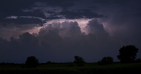 Night Storm on the Horizon. Clouds Illuminated by Lightnings. Severe Weather Photo Collection.