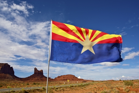 Arizona Flag on Wind. Arizona State Desert Landscape Near Monuments Valley, AZ, United States.の写真素材