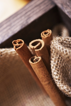 Fresh Raw Cinnamon Sticks in Wooden Crate with Canvas. Cinnamon Sticks Closeup.の写真素材