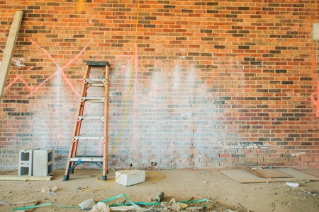 Construction Place with Small Ladder and Dirty Brick Wall.の写真素材