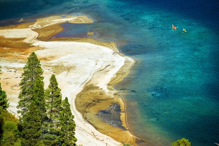 Sandy Lake Tahoe Beach with Crystal Clear Water and Some Kayakers. Lake Tahoe Recreation. California, United States.の写真素材