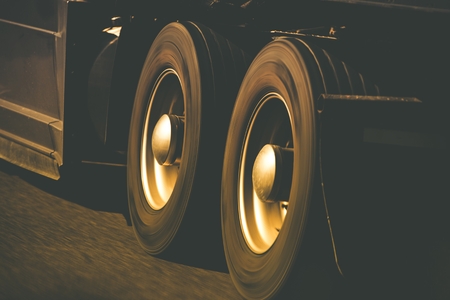 Spinning Semi Truck Wheels Closeup Photo. Browny Color Grading. Trucking and Transportation Theme.の写真素材