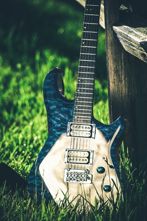 Modern Electric Guitar at Countryside Place. Wooden Fence and Summer Grass. Country Music Theme.の写真素材
