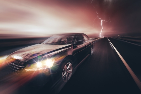 Speeding Compact Car and the Storm. Car on the Highway.の写真素材