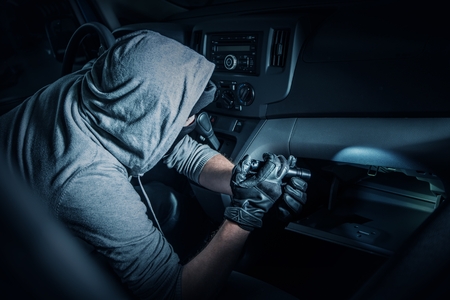 Car Rubber in the Car. Rubber with Flashlight Looking for Valuable Items Inside the Car.
