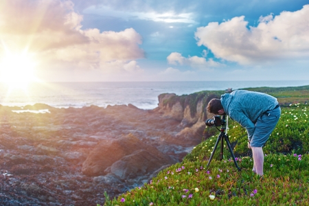 Nature Photography. Photographer on the Ocean Cliff Taking Sunset Pictures.の写真素材