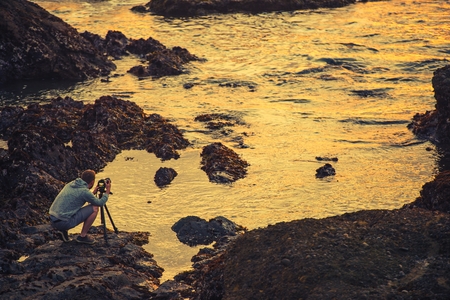 Nature Photographer Taking Ocean Sunset Pictures. Nature Photography. California Coast, United States.の写真素材