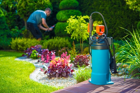 Garden Pest Control Spray and Male Gardener in the Background. Spraying Pesticides in a Garden. Gardening Theme.の写真素材