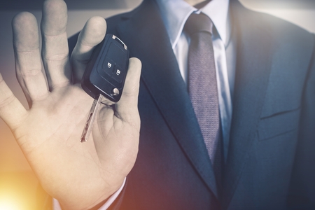 Car Salesman with Vehicle Keys. Car Selling Concept Photo. Dealership Salesman with Modern Car Keys.
