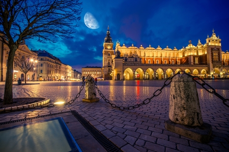 Krakow Main Market Place After Dark with Moon on the Sky. Cracow, Lesser Polandの写真素材