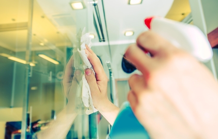 Office Windows Cleaning. Male Worker Cleaning Glass Walls in the Office Area. Cleaning Service.