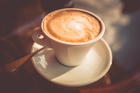 Fresh Tasty Cup of Coffee Closeup Photo. Coffee Cup on Glassy Table.の写真素材
