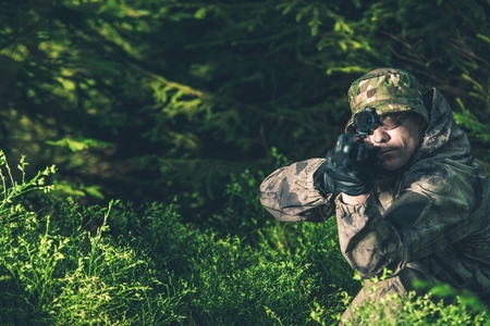 Forest Hunter. Poacher with Rifle Spotting Some Deers.の写真素材