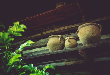 Vintage Earthenware on a Shelf Outside of Old Log Cabin. Aged Ceramic Crocks.の写真素材