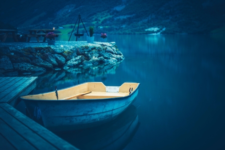 Aged Boat and the Blue Glacial Lake. Recreational Place with Wooden Table.の写真素材