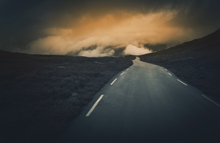 Uncertain Road Ahead. Dark and Cloudy Mountain Road Journey. Rocky Norway Landscape.