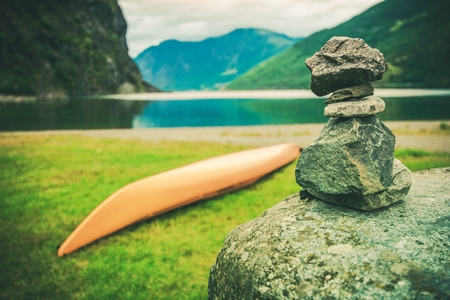 Destination Norway Cairn. Norwegian Fjord, Kayak and Pile of Stones Left by Tourist.の写真素材