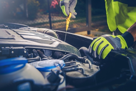 Car Mechanic Checking Oil Level in Modern Car Engine.の写真素材