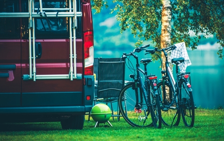 RV Camper Camping and Biking. Motorcoach and Two Bikes on the Campsite.の写真素材