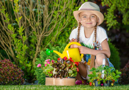 Caucasian Girl Taking Care of the Garden. Watering Flowers.の写真素材